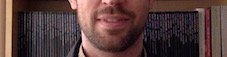 Head and shoulders photo of Nils. White male wearing a pink shirt and dark brown jacket